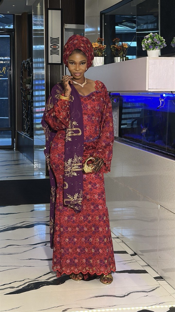 Woman in traditional Nigerian attire with natural glam makeup and headwrap